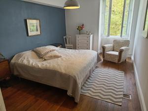 une chambre avec un lit et une chaise dans l'établissement Moulin de Bellicout, à Charmé 29 autres photos