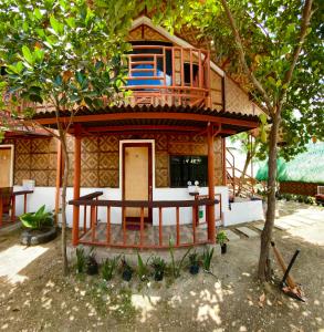 een klein huis met een balkon erboven bij TopBudz Hostel Panagsama Moalboal Couple in Moalboal