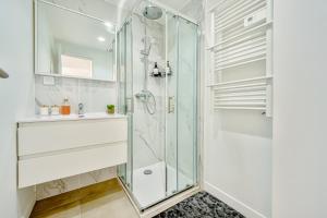 une salle de bain avec une douche en verre et un lavabo dans l'établissement Air-conditioned Apartment - Sea View Port, à Toulon