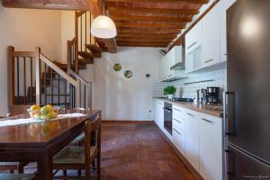 cocina con armarios blancos y techo de madera en Agriturismo La Gioconda, en Vinci