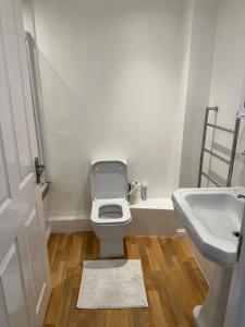 a bathroom with a toilet and a sink at Lovely Two Bedroom Flat in Thamesmead