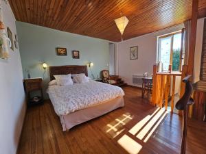 sypialnia z łóżkiem i drewnianym sufitem w obiekcie Gîte des Gravets w mieście Sigalens