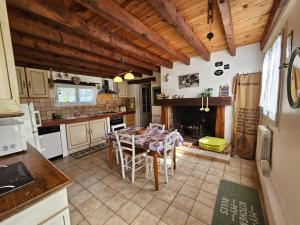 a kitchen with a table and a dining room at Gîte des Gravets in Sigalens