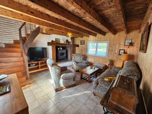 a living room with couches and a television in a cabin at Gîte des Gravets in Sigalens +50 photos