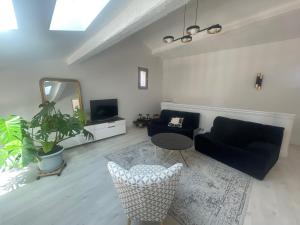 a living room with a couch and a table and a mirror at La villa des Carriers- maison avec piscine proche mer in Roquefort-les-Pins