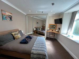 a bedroom with a bed and a desk and a mirror at Victoria Apartments in Torquay