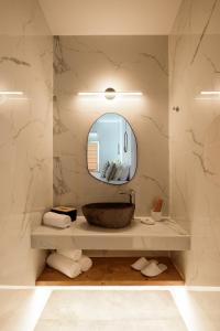 a bathroom with a sink and a mirror at Lotus Suites in Fira
