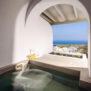 a pool in a house with a view of the ocean at Lotus Suites in Fira