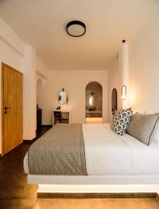 a bedroom with a large white bed in a room at Lotus Suites in Fira