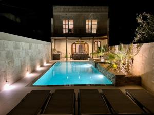 a swimming pool in front of a house at night at Ta Lucija - Luxurious 6 Bedroom/En suite Villa - Pool / AC in Santa Luċija