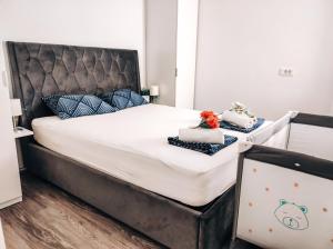 a bedroom with a large bed with white sheets and blue pillows at Apartment Kino in Ljubljana