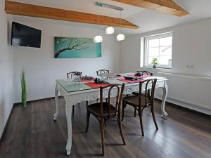 a dining room with a white table and chairs at Ferienwohnung am Schwimmteich 2 in Lachendorf +4 photos