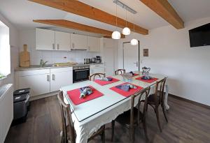 a kitchen with a white table with red napkins at Ferienwohnung am Schwimmteich 2 in Lachendorf