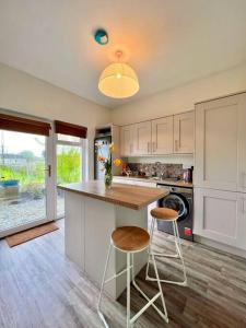 a kitchen with a counter and two stools in it at Moate - One Bedroom Self Contained Apartment in Moate