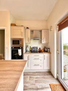 cocina con armarios blancos y fogones en Moate - One Bedroom Self Contained Apartment en Moate
