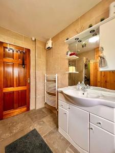 a bathroom with a sink and a wooden door at Moate - One Bedroom Self Contained Apartment in Moate