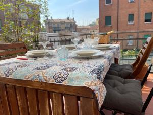 “Al 57”…. a quiet corner in Ferrara في فيرّارا: طاولة مع أطباق وكؤوس للنبيذ على شرفة