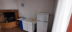 a kitchen with a white refrigerator and a table at CASA DEBORAH in Alliste