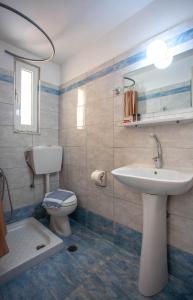 La salle de bains est pourvue d'un lavabo et de toilettes. dans l'établissement Lucia Hotel, à La Canée