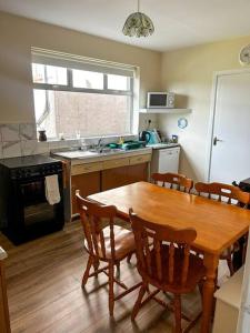 a kitchen with a wooden table and a table and chairs at Sneem Townhouse in Sneem