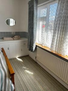 een slaapkamer met een bed en een raam met gordijnen bij Sneem Townhouse in Sneem