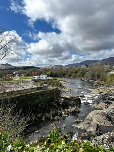 a river with rocks and a bridge in a town at Sneem Townhouse in Sneem