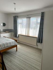 a bedroom with a bed and two windows at Sneem Townhouse in Sneem