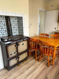a kitchen with a wooden table and a stove at Sneem Townhouse in Sneem