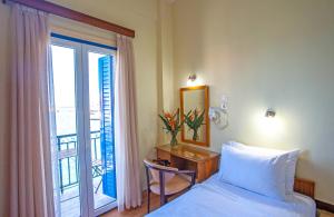 a bedroom with a bed and a desk with a window at Lucia Hotel in Chania Town