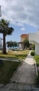 a walkway in front of a house with a palm tree at Christy's apartment by the sea in Skála Foúrkas