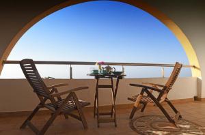 two chairs and a table in front of a window at Panorama in Armenistis