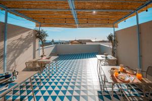 a rooftop patio with tables and a tile floor at DIMORA NIKARE' Sicilian House in Sciacca