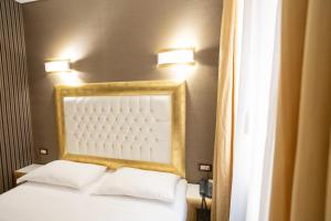 a bedroom with a bed with two pillows and two lights at Duomo Boutique Hotel in Chioggia