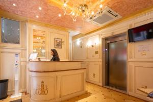 a woman sitting at a counter in a room at Duomo Boutique Hotel in Chioggia