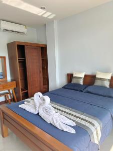 a bedroom with a bed with towels on it at Triple O Phala Beach in Ban Phala