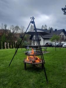 a grill with a fire in a yard at Noclegi u Nawary in Rabka-Zdrój