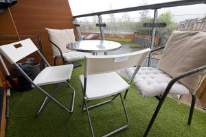 a group of chairs and a table on a balcony at Exclusive Stylish Lodge in Manchester