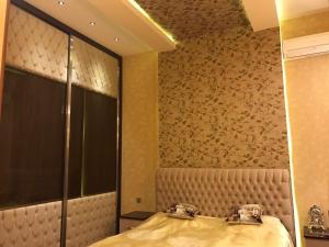 een slaapkamer met een bed en een bruine muur bij BAKU SAHIL LUX DUPLEX in Baku