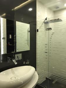 een badkamer met een wastafel en een glazen douche bij BAKU SAHIL LUX DUPLEX in Baku