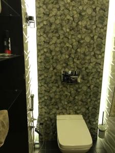 een badkamer met een toilet en een stenen muur bij BAKU SAHIL LUX DUPLEX in Baku