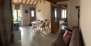 salon z kanapą, stołem i krzesłami w obiekcie chambre salon indépendant, salle de bain wc privés, jardin privé, piscine partagée près d'un lac w mieście Mesnil-Saint-Père