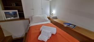 Una habitación con una cama con dos toallas blancas. en Casa DON PEPPE, en Taormina