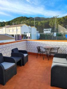eine Terrasse mit Stühlen und Tischen auf dem Dach in der Unterkunft Casa Blanca w sercu Andaluzji / Finca / Village House in Montecorto