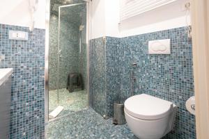 a blue tiled bathroom with a toilet and a shower at Duomo Boutique Hotel in Chioggia