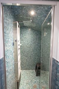 a bathroom with a shower with green tiles at Duomo Boutique Hotel in Chioggia