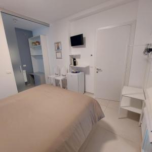 Habitación blanca con cama y TV en Bed & Breakfast A Mare, en Fano