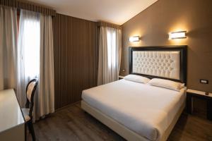 a hotel room with a bed and a window at Duomo Boutique Hotel in Chioggia