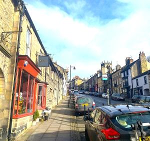 a city street with cars parked on the street at Spacious Georgian Apartment, Central Barnard Castle. in Barnard Castle