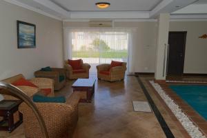 ein Wohnzimmer mit Stühlen und einem Pool in der Unterkunft Palazzo Gardens -Self catering Guesthouse in Swakopmund