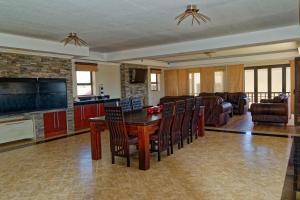 cocina y sala de estar con mesa de madera y sillas en Palazzo Gardens -Self catering Guesthouse, en Swakopmund